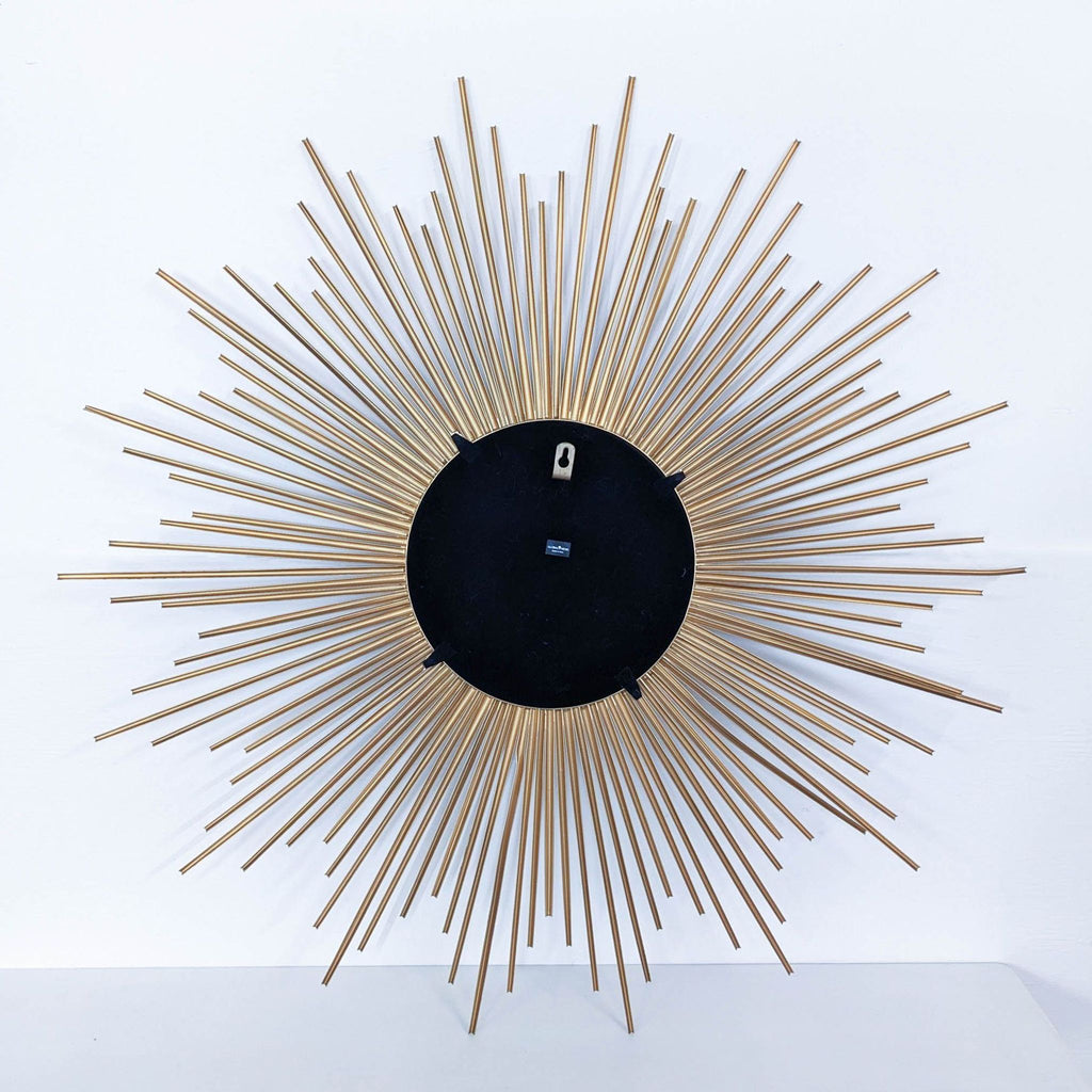 a large, circular, brass sunburst mirror.