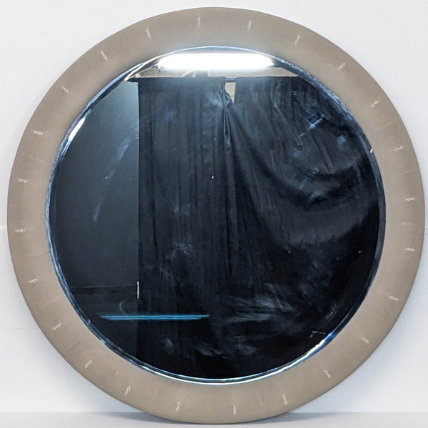 a large oval mirror with a silver frame and a black curtain.