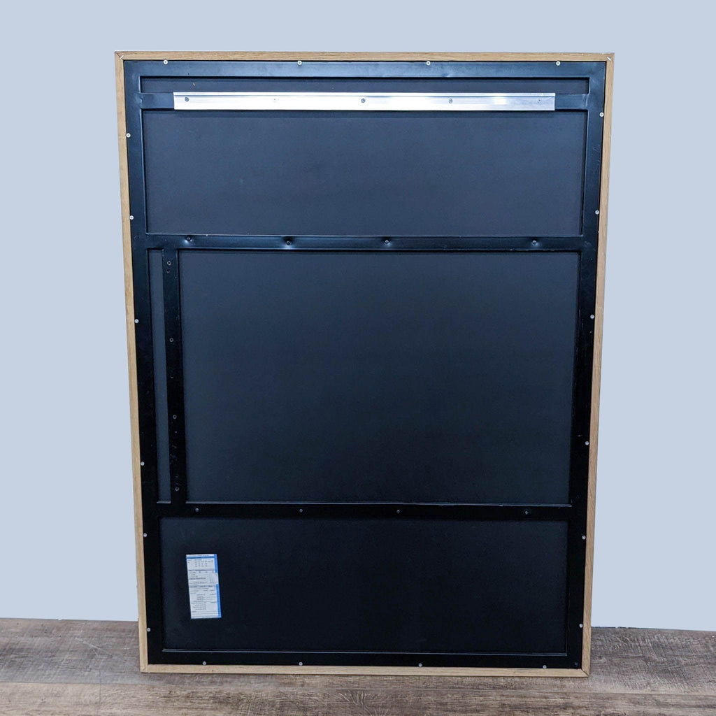 Back view of the mirror with black backing and wooden frame.