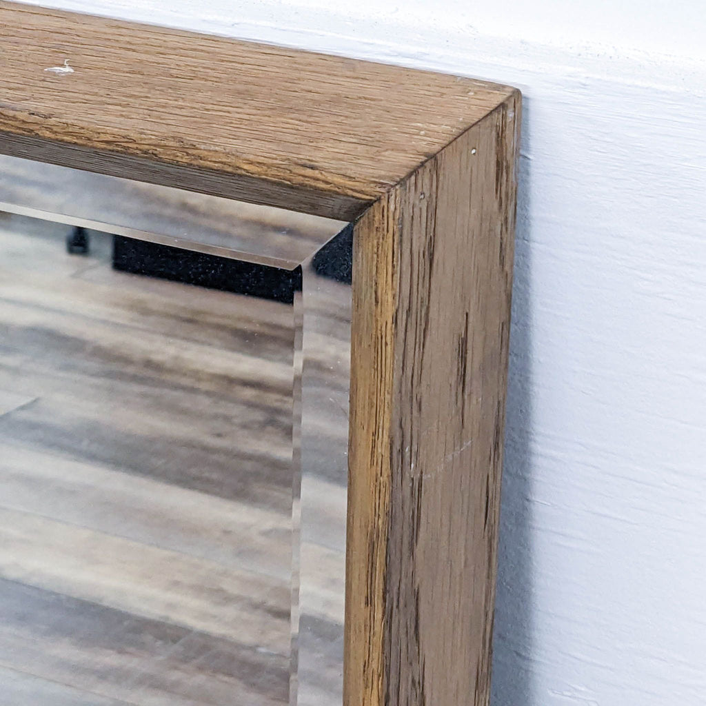 Close-up of oak wood frame and beveled edge of the mirror.