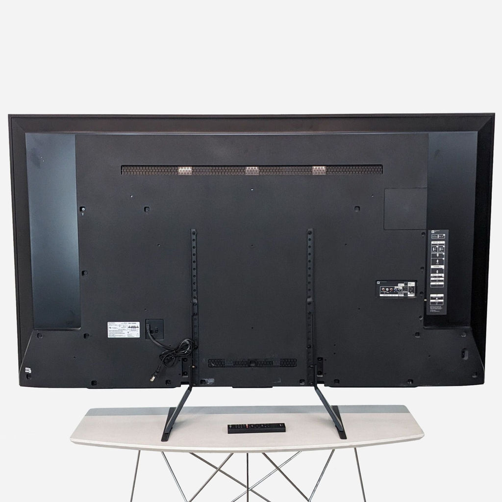 the tv is a large, flat screen tv that is mounted on a stand.