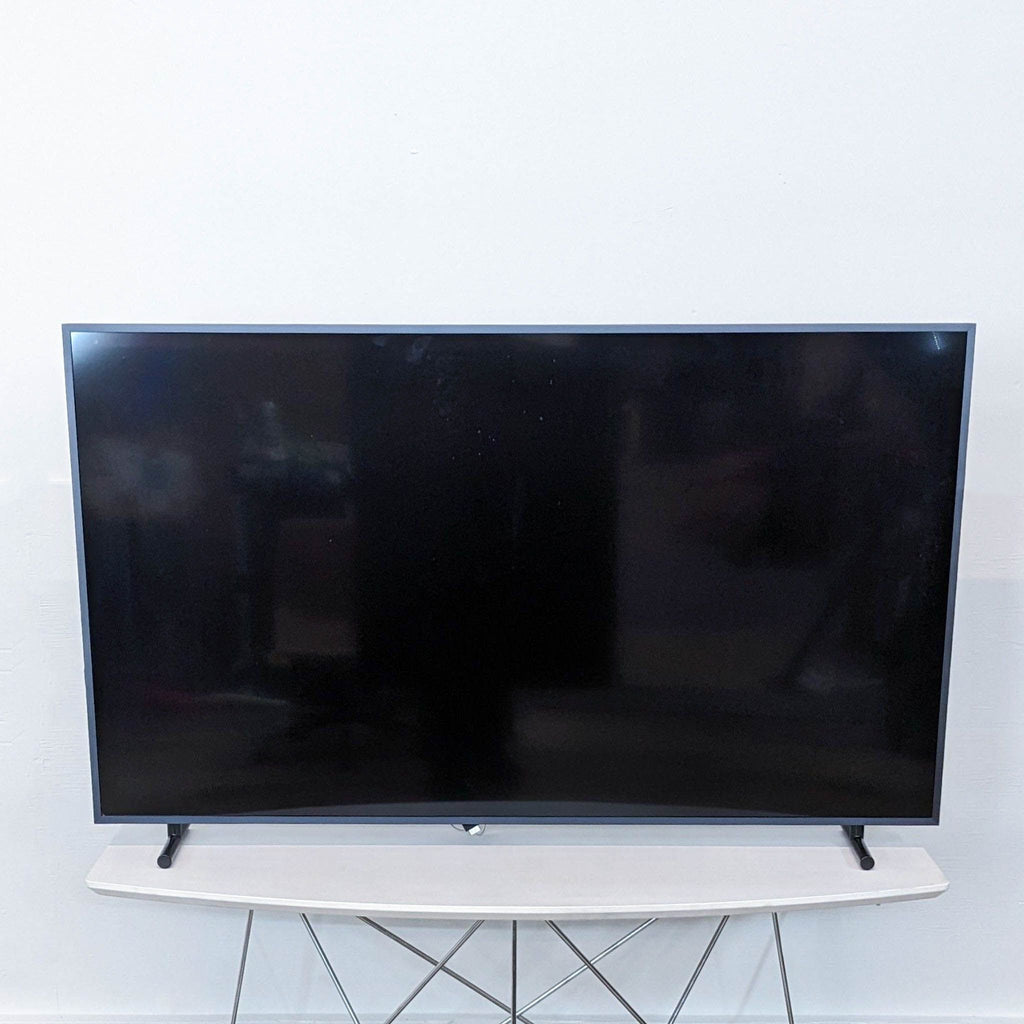 a flat screen tv sitting on a white table.