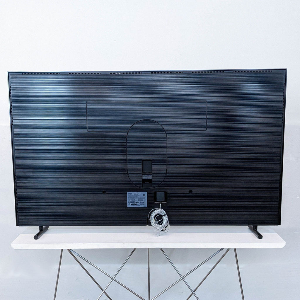 a black tv sitting on a white table.