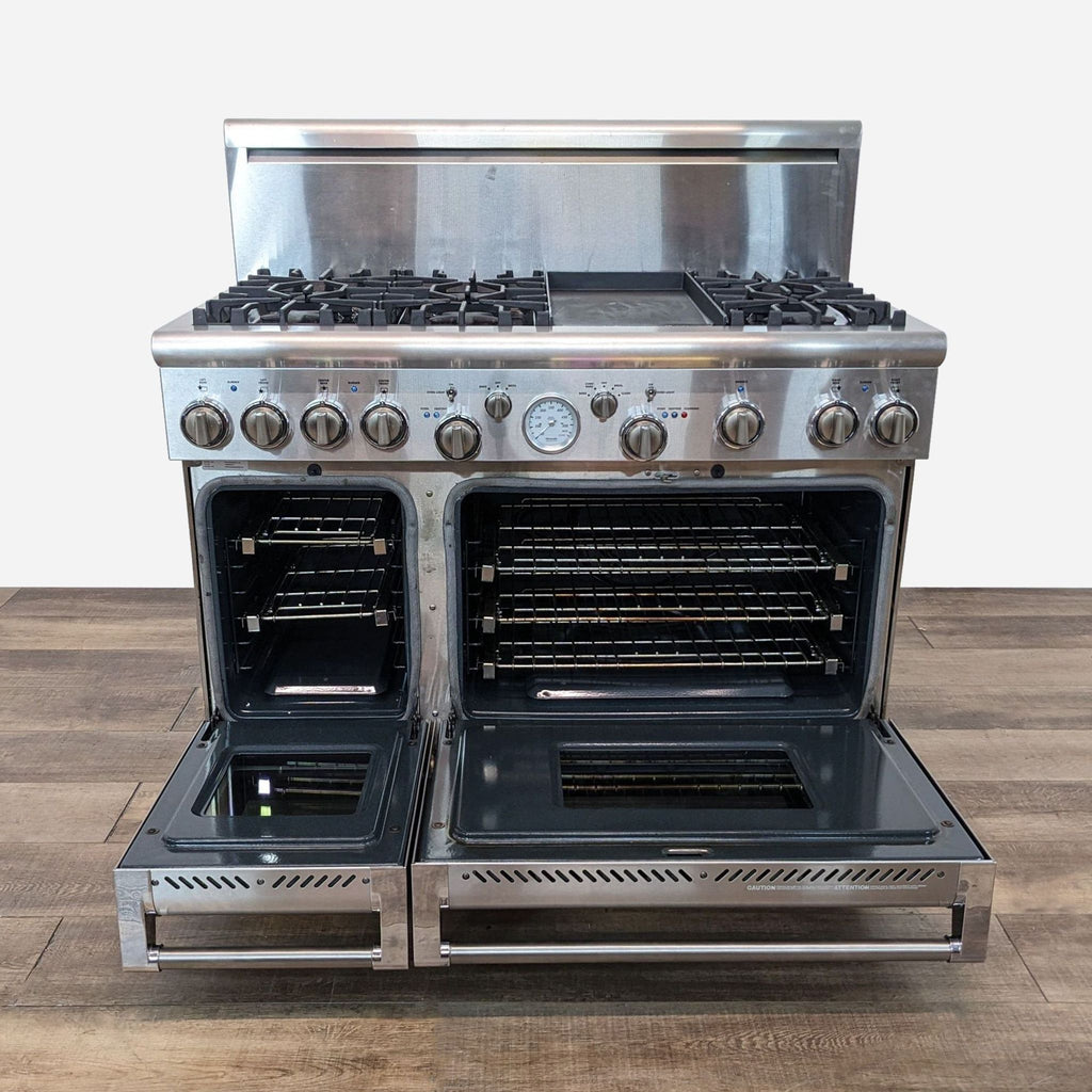 a stainless steel stove with four burners on a wooden table.