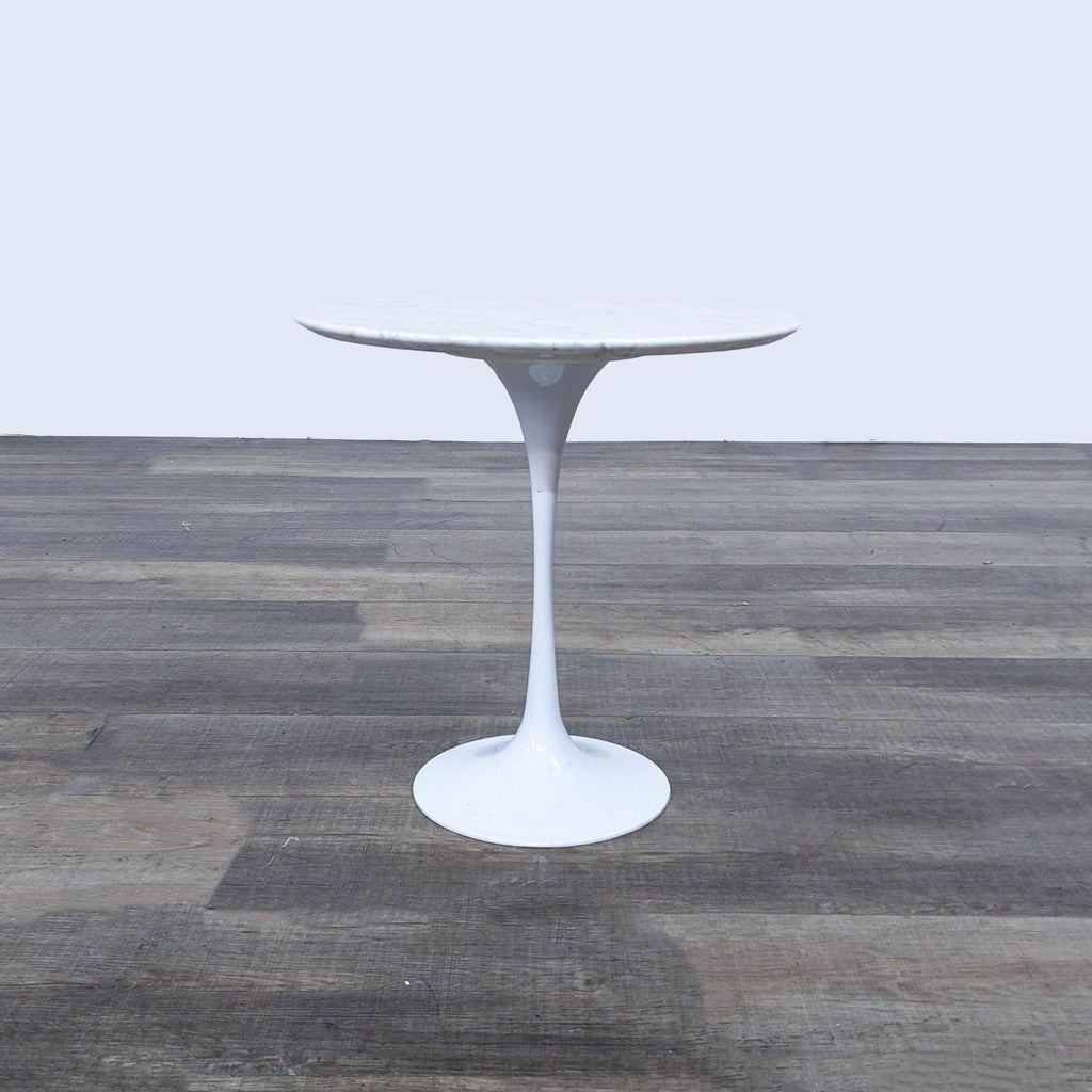 a chrome table with a white base and a round base.