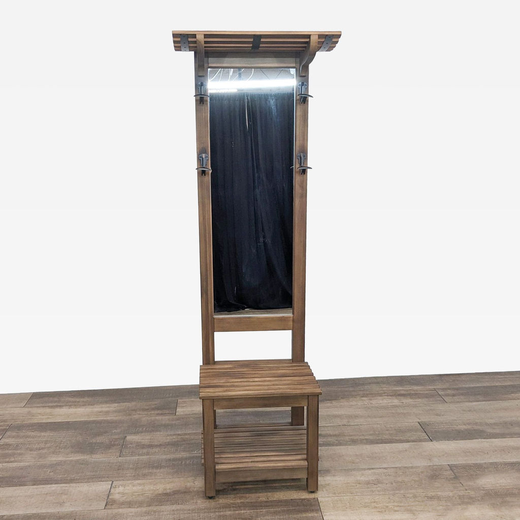 Front view of a wooden hall tree with a mirror, hooks, and a bench with storage.