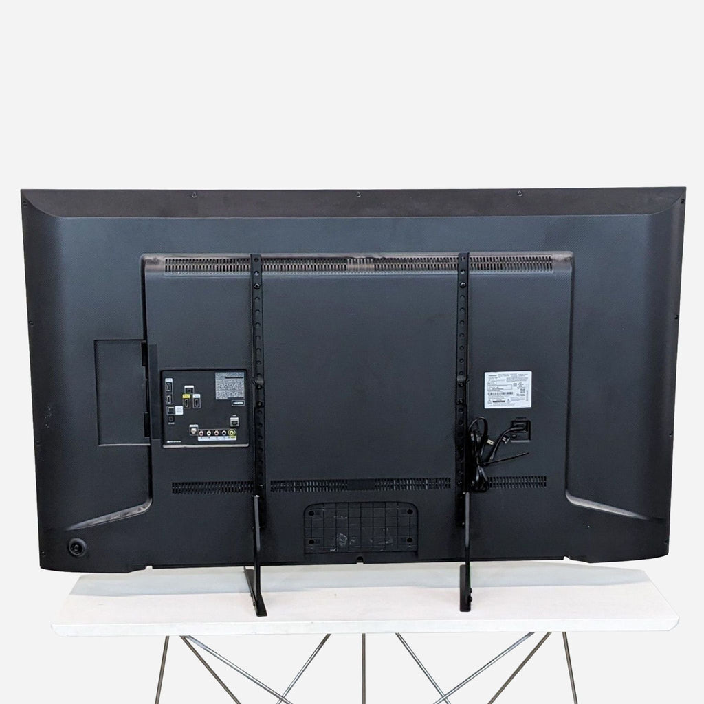 a large black tv set on a white table.