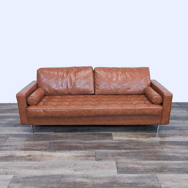 a brown leather sofa with a chrome base and a chrome base.