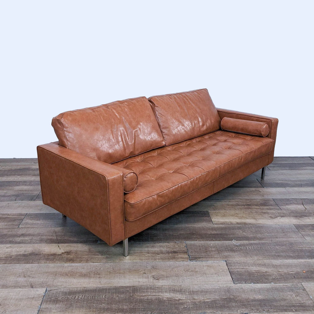 Angled view of Reperch leather sofa, showcasing tufted seat and plush cushions.