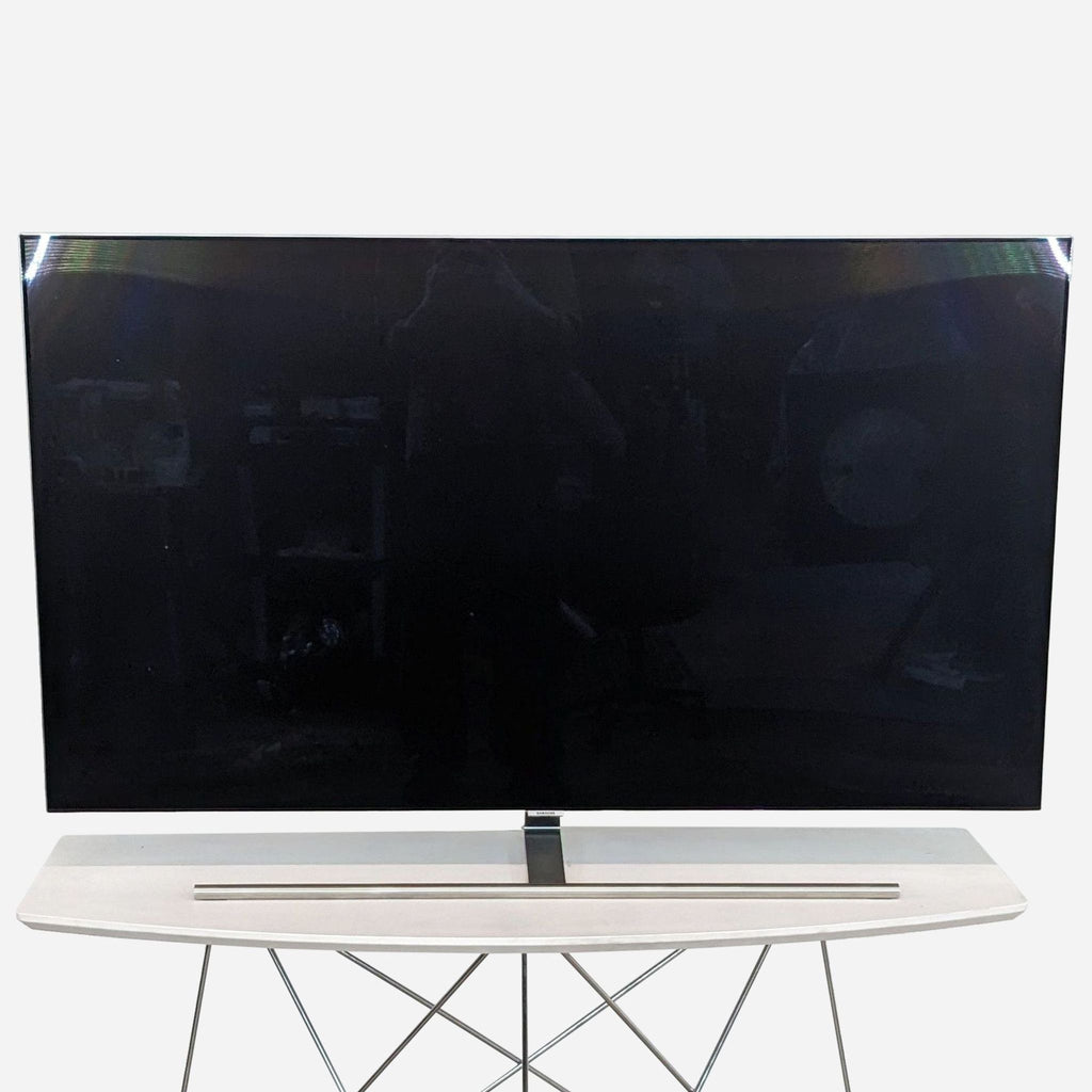 Front view of a 55-inch Samsung QLED TV on a modern stand.