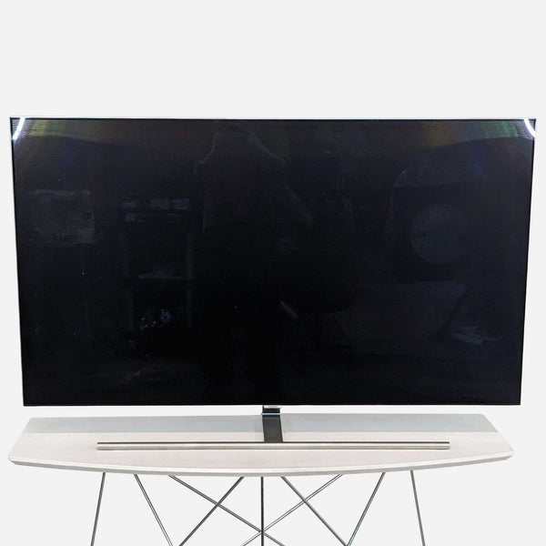 Front view of a 55-inch Samsung QLED TV on a modern stand.