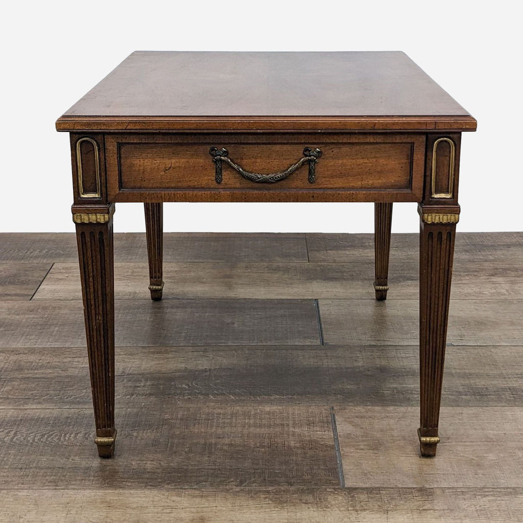 a small, antique, mahogany side table with a brass handle.