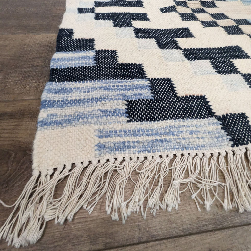 Fringed edge of West Elm rug showcasing detailed craftsmanship and dyed wool fibers.