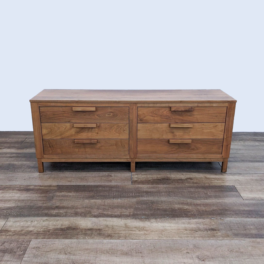 Mid-century modern dresser with six drawers and wood handles.