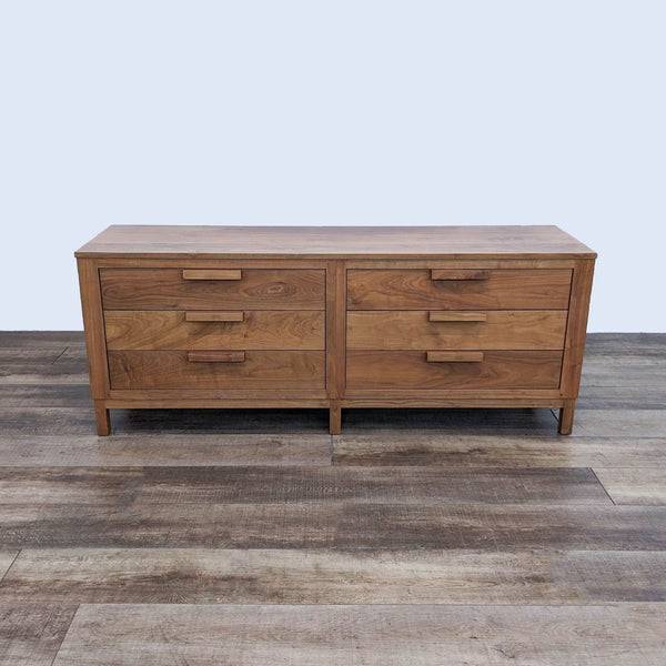 Mid-century modern dresser with six drawers and wood handles.
