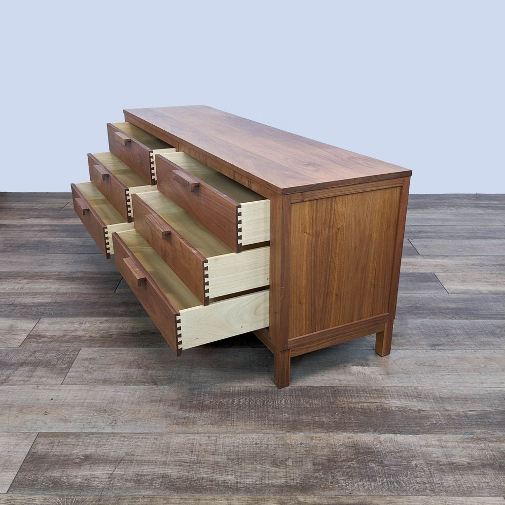 Solid wood dresser, side view with open dovetail drawers.