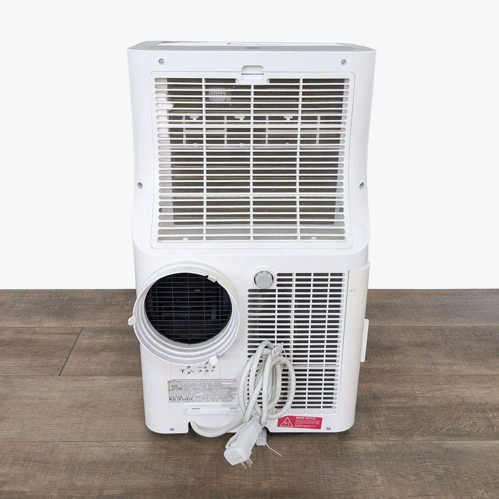 a white air conditioner with a white back and a black cord.