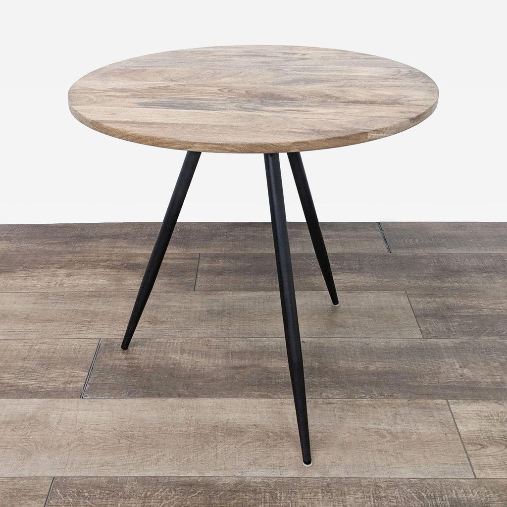 Compact dining table featuring a round top and slim tripod base.