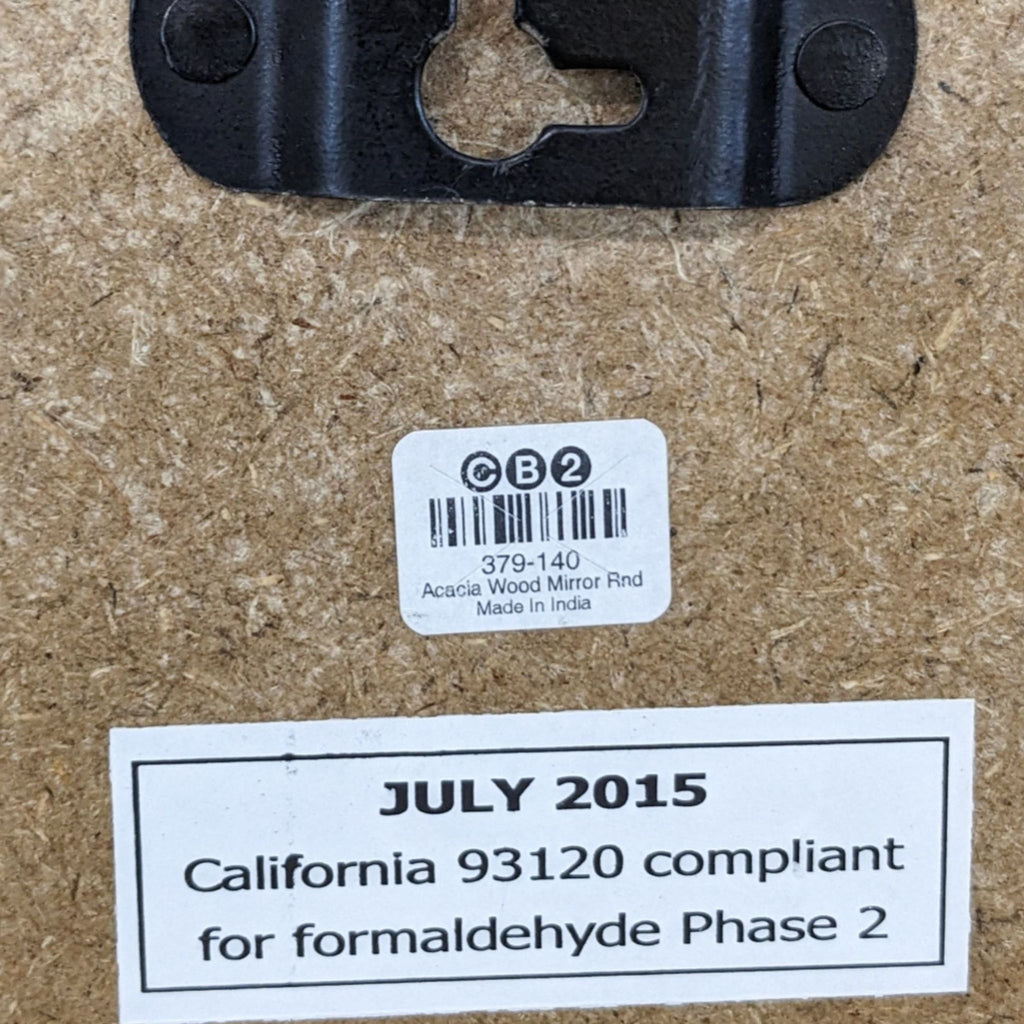 Close-up of CB2 mirror’s back, displaying a barcode, brand label, and formaldehyde compliance sticker.