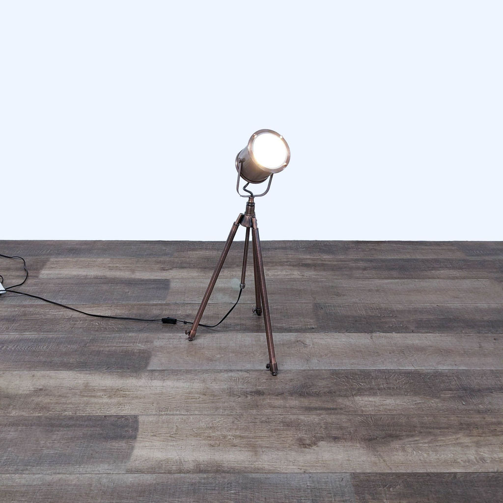 Spotlight lamp on a tripod base plugged in and illuminating a room.