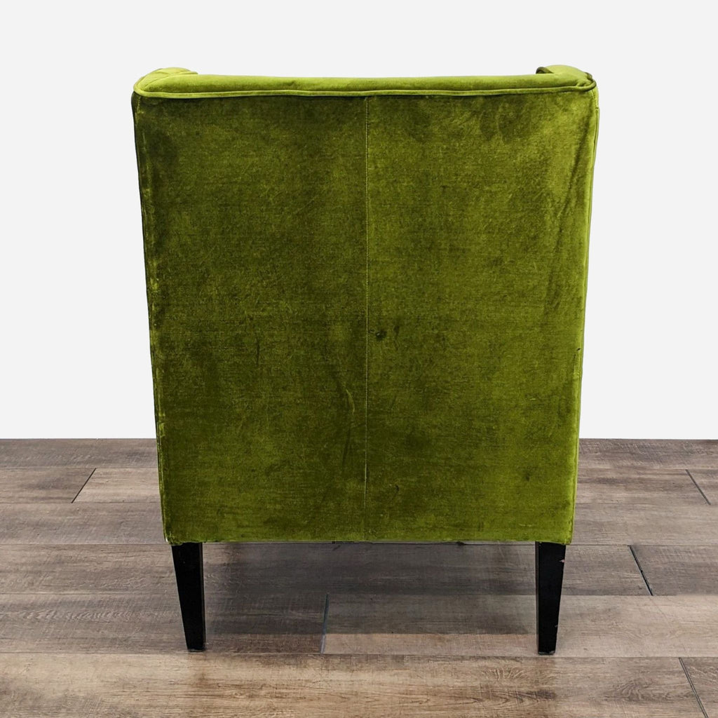 a green velvet chair with black legs