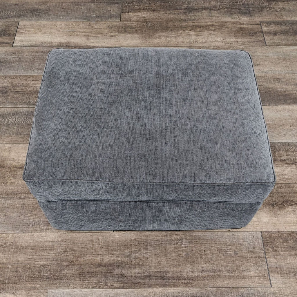 the gray ottoman is a modern ottoman that is perfect for any room.
