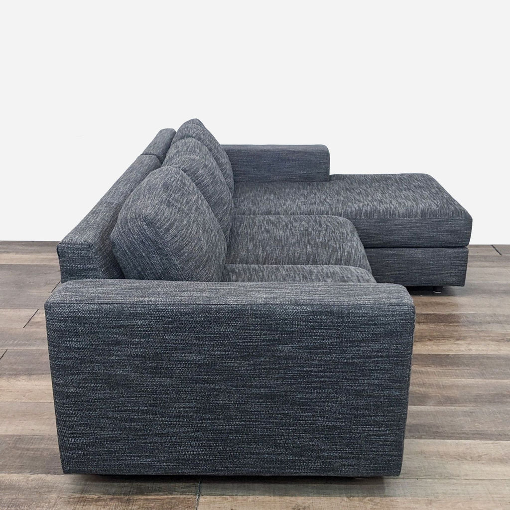 Side view of a gray West Elm sectional sofa with a spacious chaise, highlighting a sleek profile.  