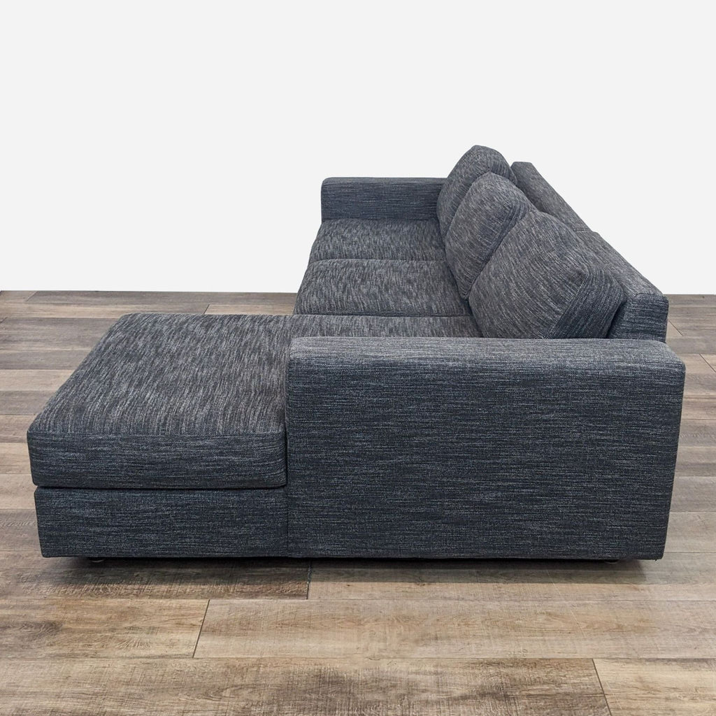 Modern gray sectional by West Elm, featuring a chaise on wooden flooring in a contemporary style.