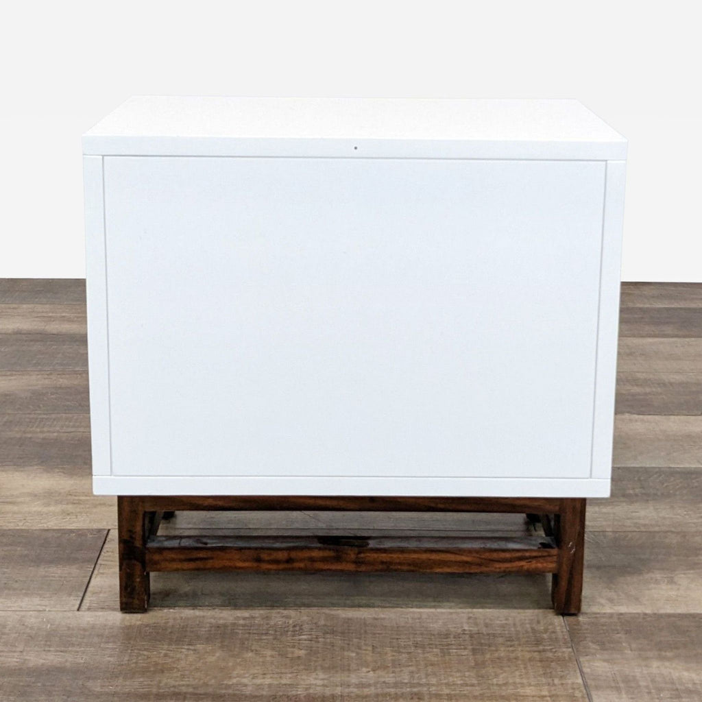 a modern white lacquer side table with a dark wood base.