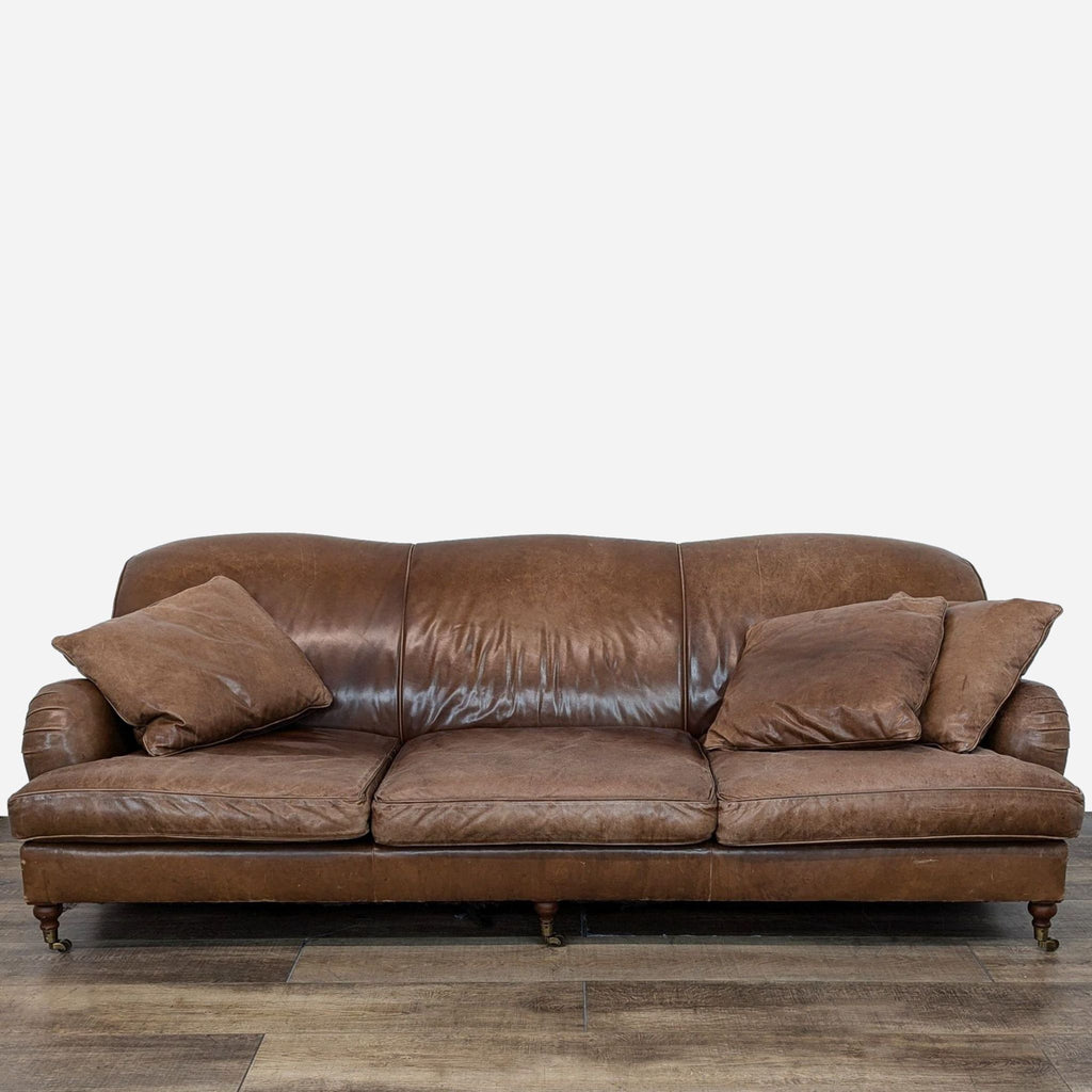 Ralph Lauren brown leather sofa with curved lines and wood feet.
