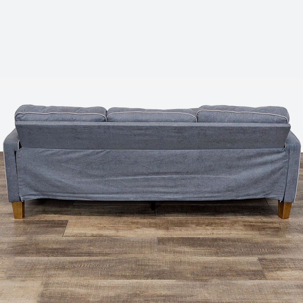 Back view of Dorel sectional featuring chenille fabric, track arm design, and solid wood pyramid feet.