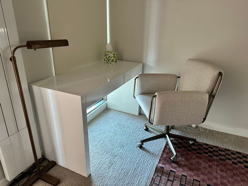 1. Modern white CB2 desk with clean lines, paired with a light gray office chair in a cozy corner.