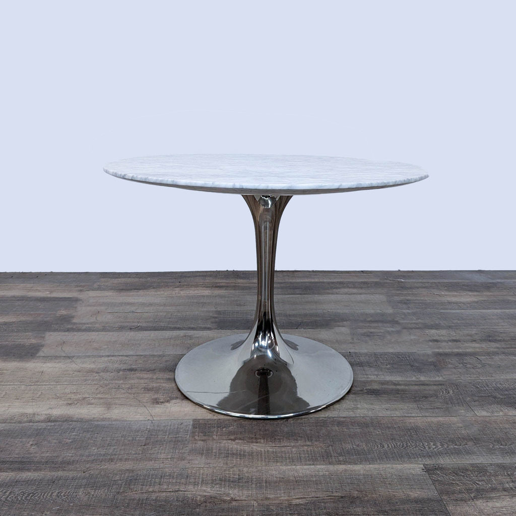 a chrome and glass table with a round base.