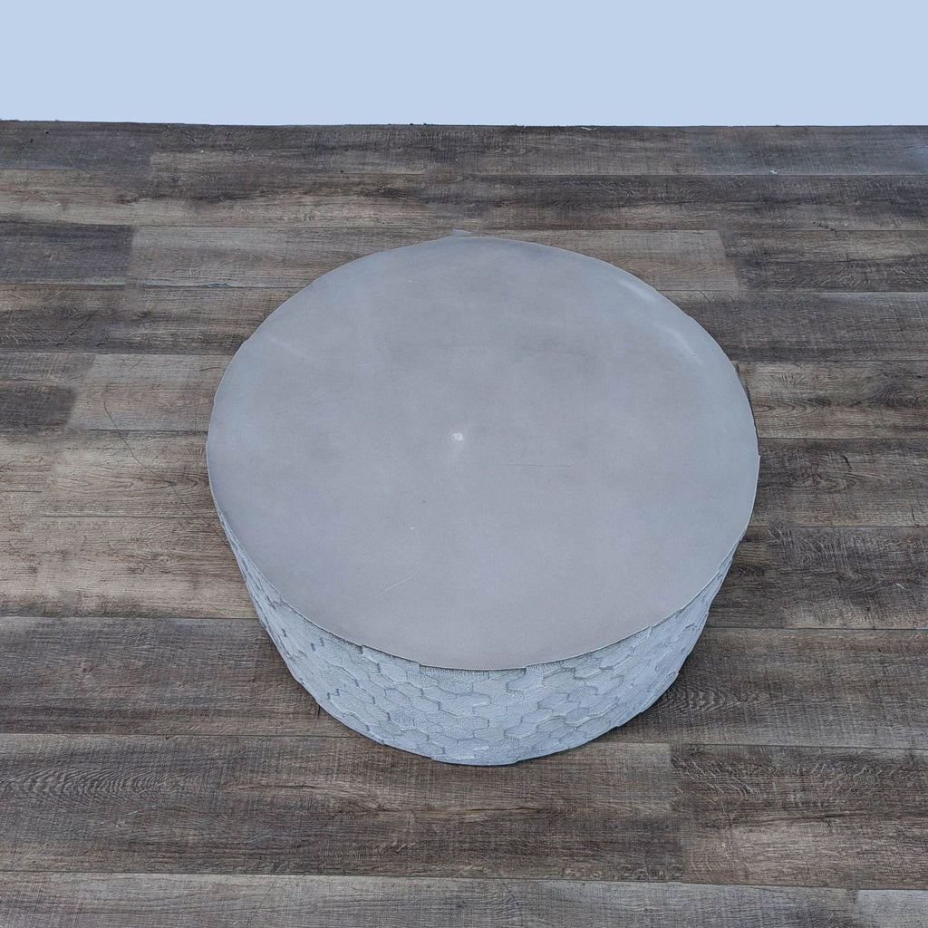 a round, concrete, and ceramic table top with a round base.