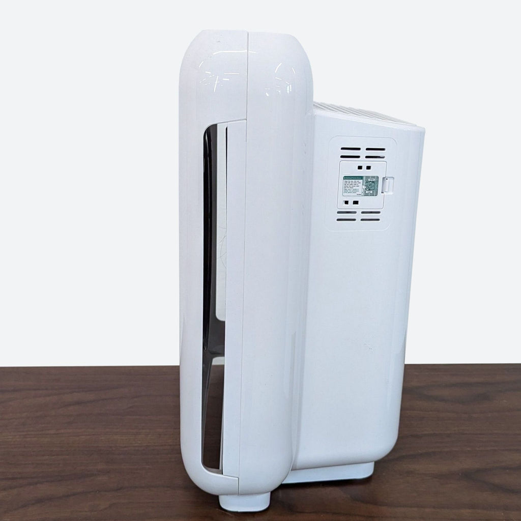 a white air conditioner on a wooden table.