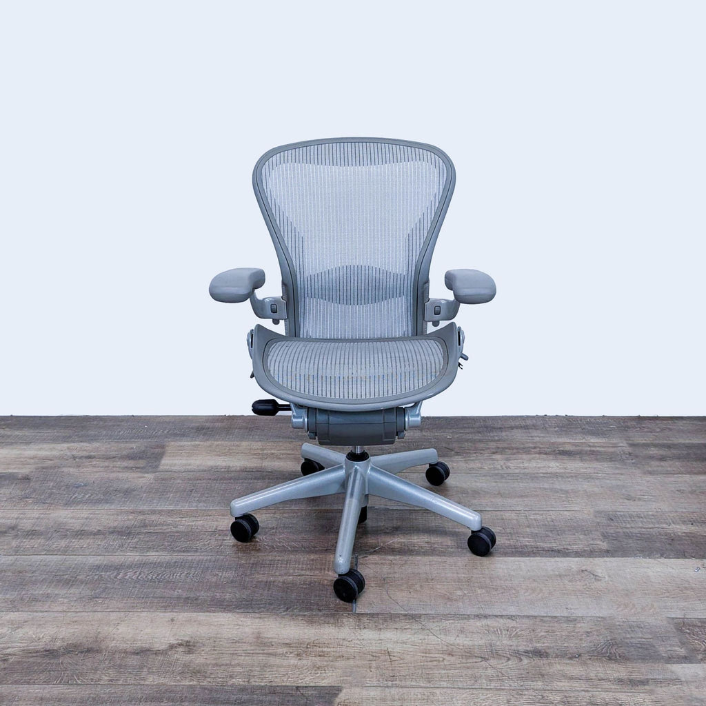 Front view of Herman Miller Aeron chair with mesh back and adjustable arms.