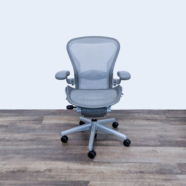 Front view of Herman Miller Aeron chair with mesh back and adjustable arms.