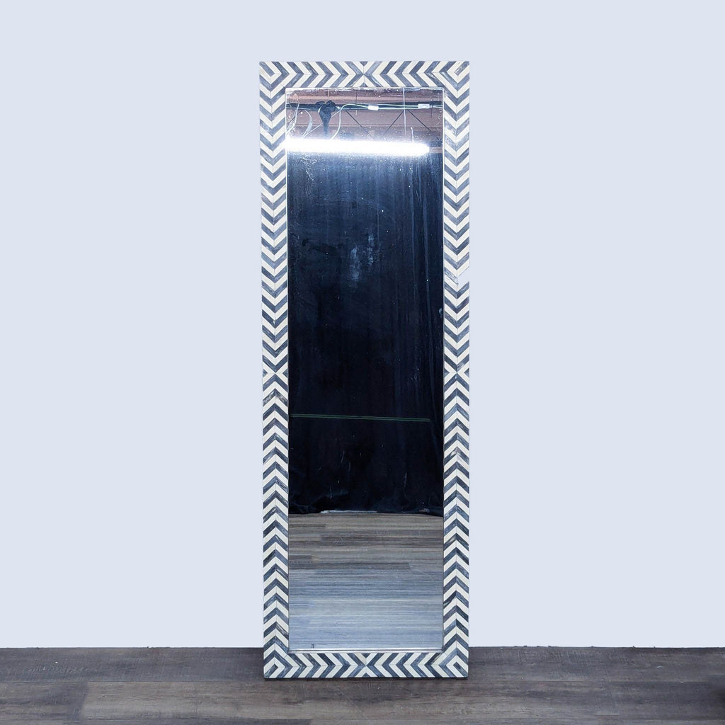 a large mirror with a black and white chevron pattern.