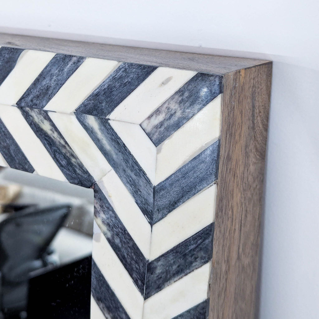 a black and white marble mirror with a black and white chevron pattern.