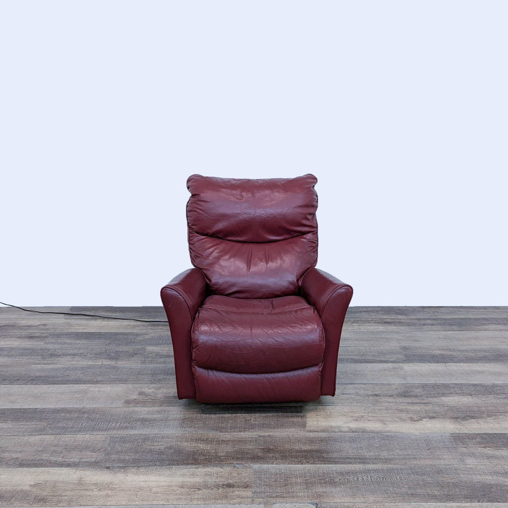 a red leather recliner chair in a room with a wooden floor.