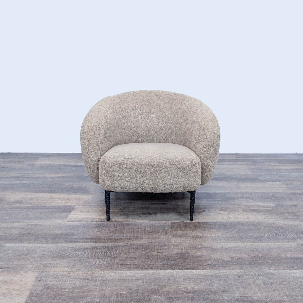 A cozy, rounded lounge chair with textured fabric and minimalist legs from Banana Republic Home.