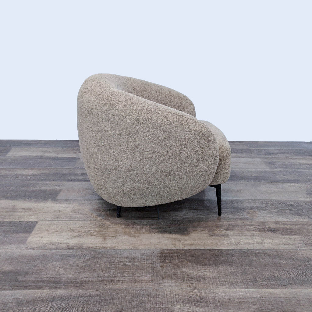 Side view of a plush, curved lounge chair with a generous backrest, showcasing its modern design.