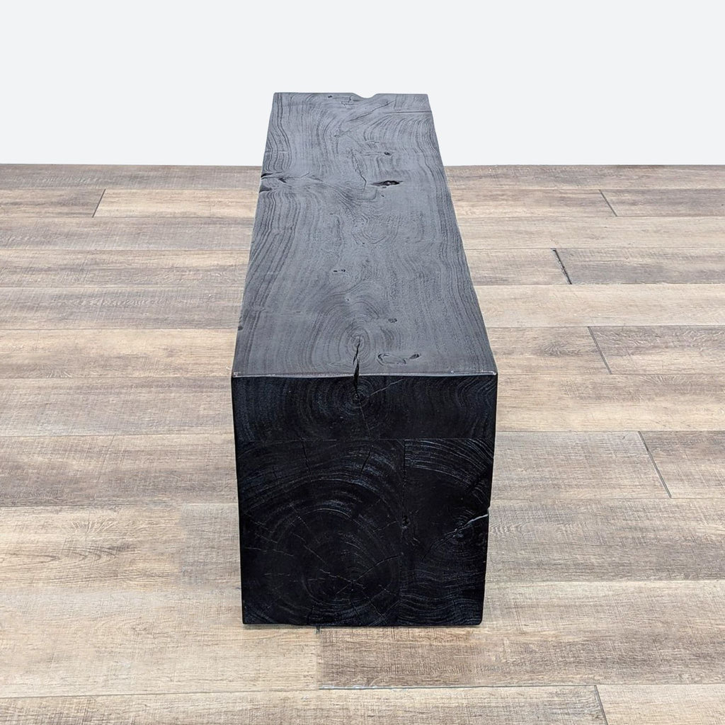 a black wooden bench with a thick black surface.