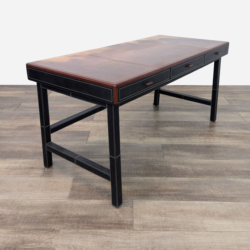 a vintage desk with a leather top and a drawer.