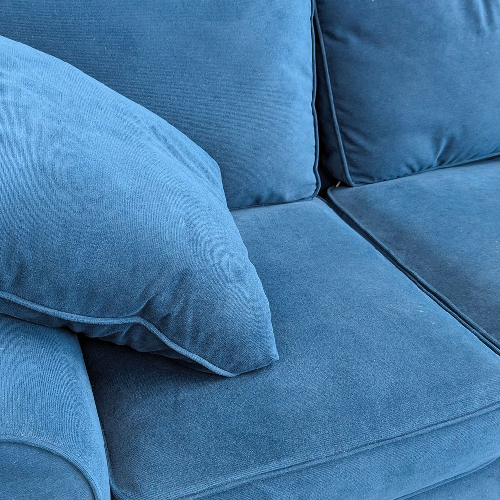 a blue sofa with two pillows.