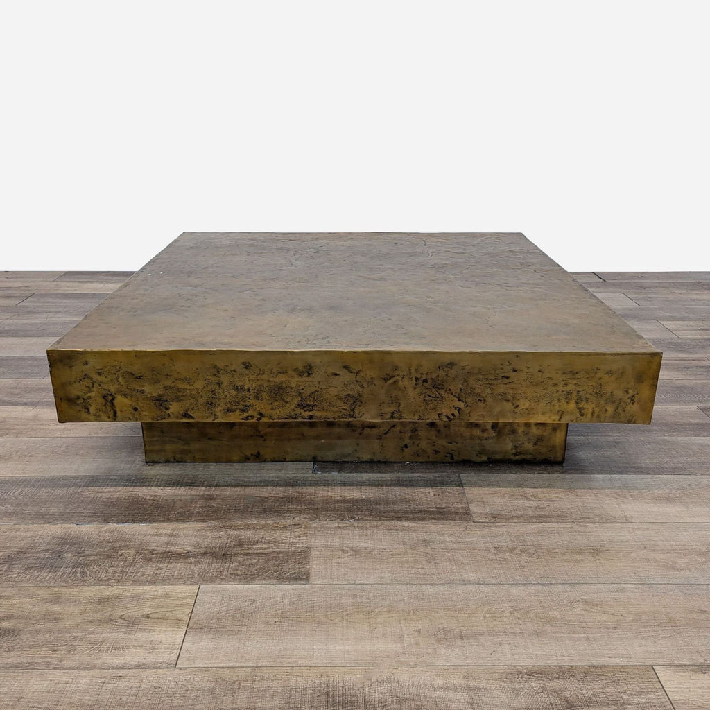 a large bronze coffee table with a large square top.