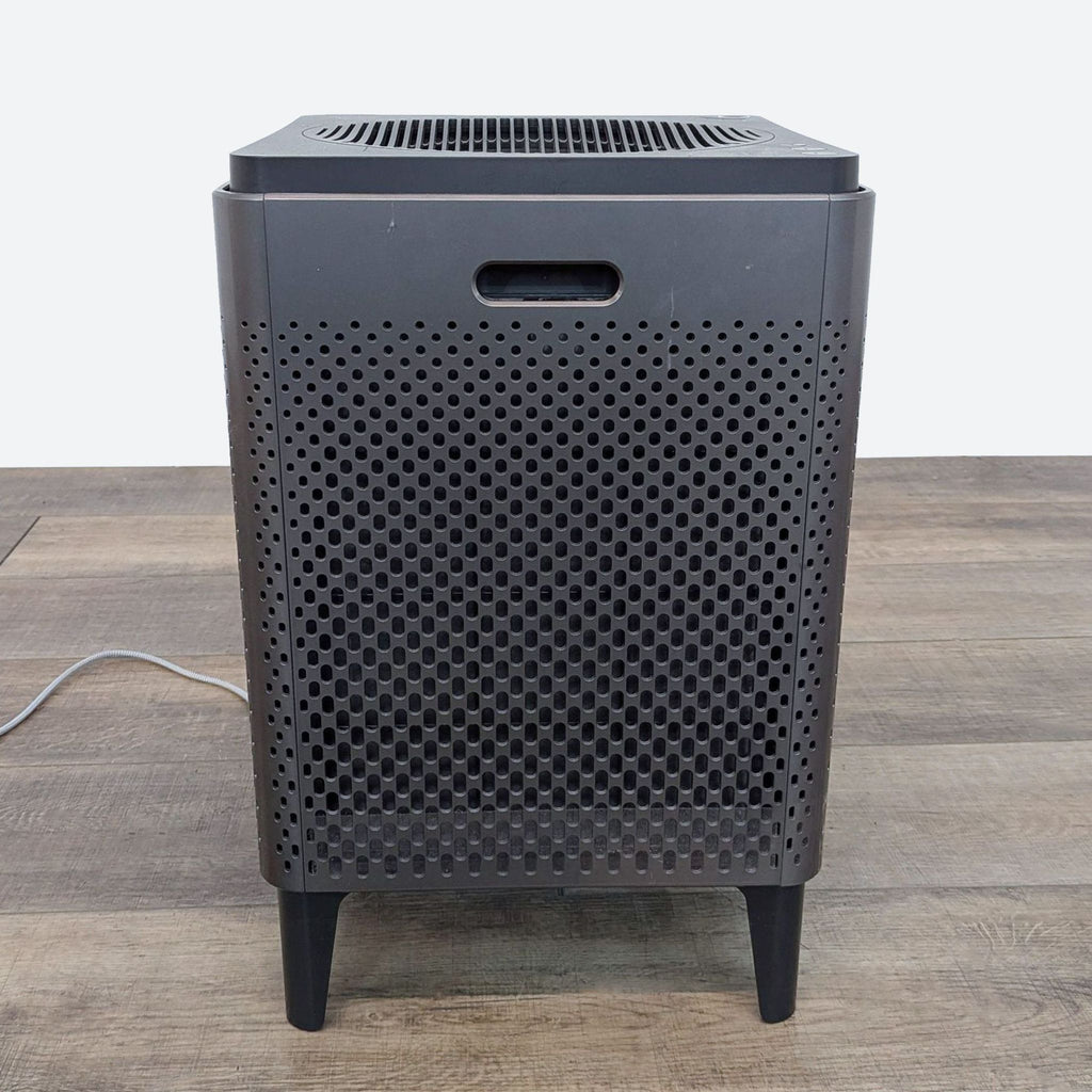 a black speaker on a wooden floor.