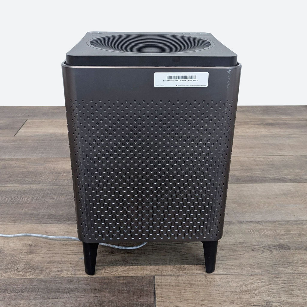a close up of a black and silver air conditioner on a wooden floor.