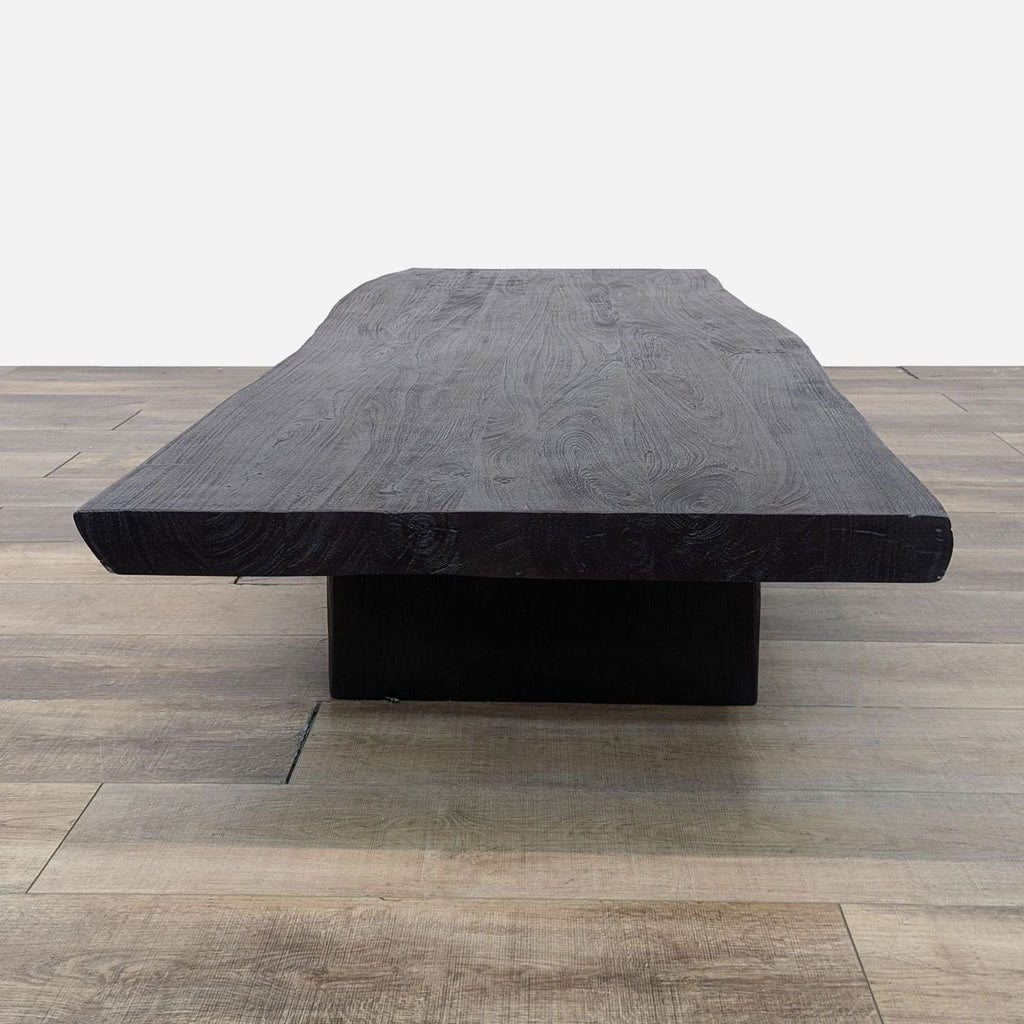 a large black coffee table with a thick slab of wood.