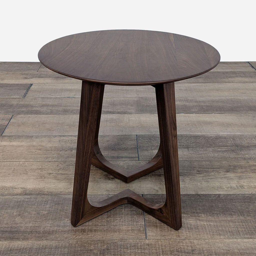 Elegant wooden end table by Reperch, featuring a circular top and sleek legs.